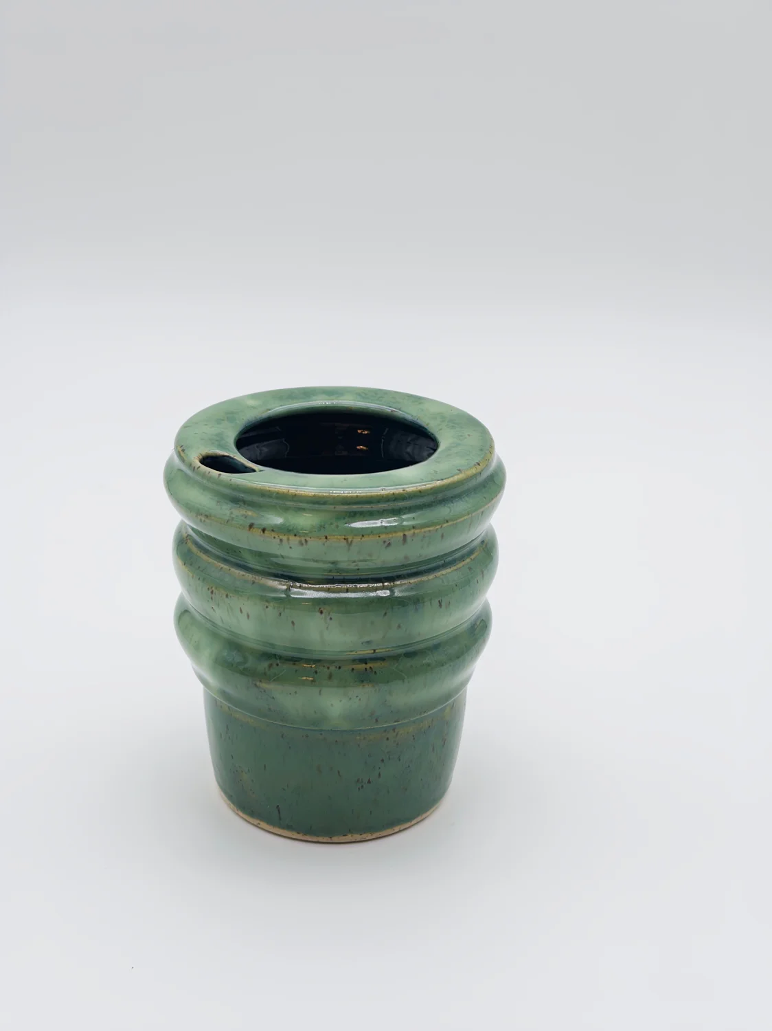 Green travel cup with ridged sides and a sipping opening