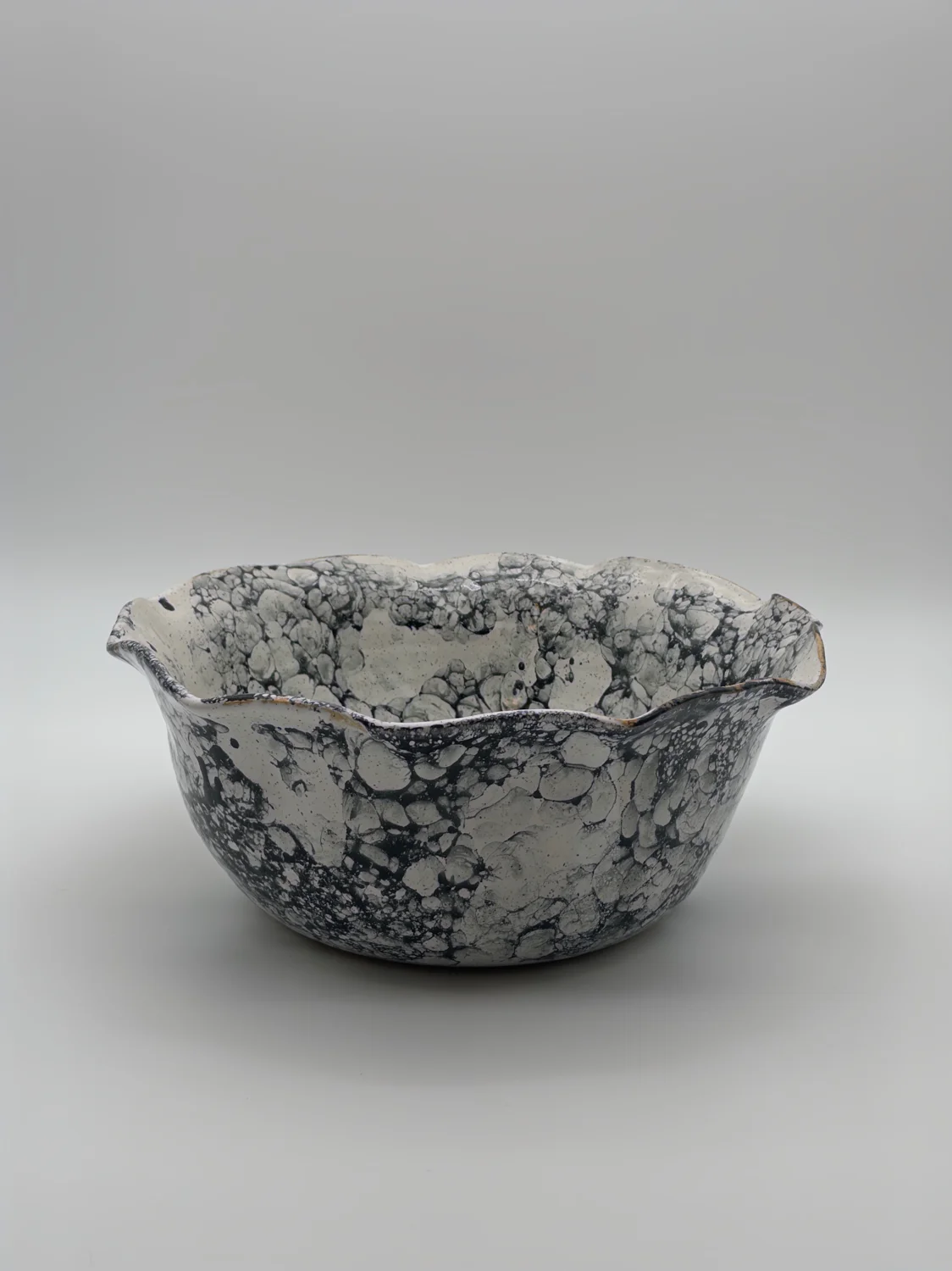 Large white bowl with a black bubble pattern and a wavy rim