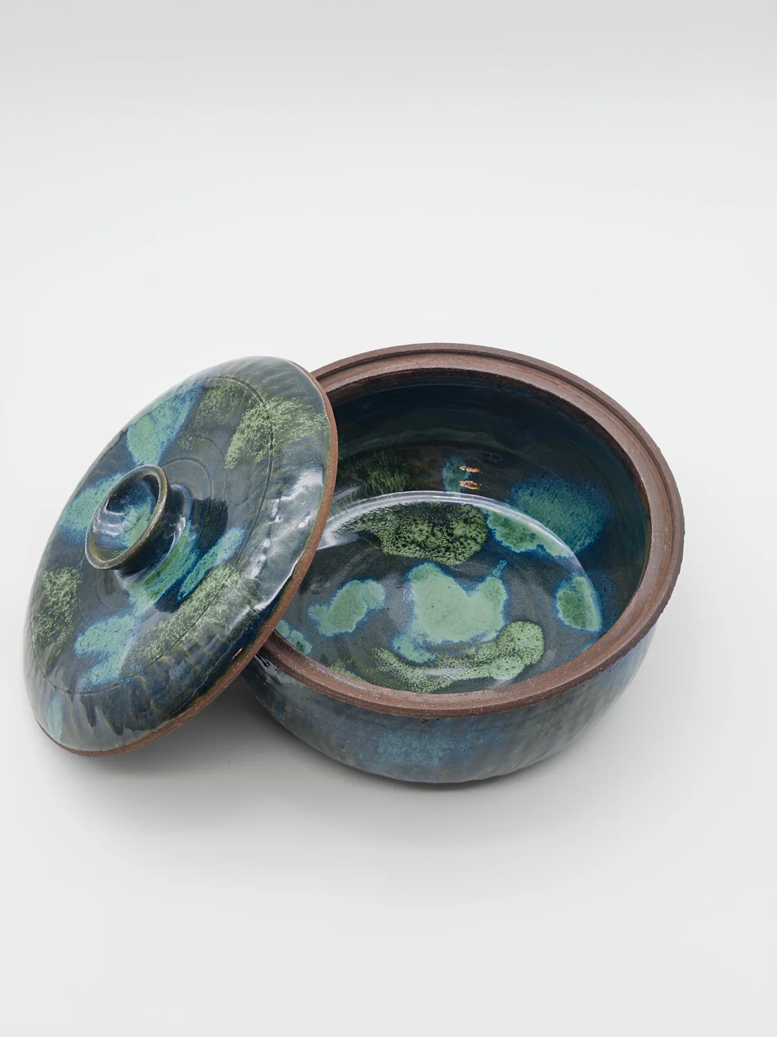 Blue and green lidded jar with a patterned interior