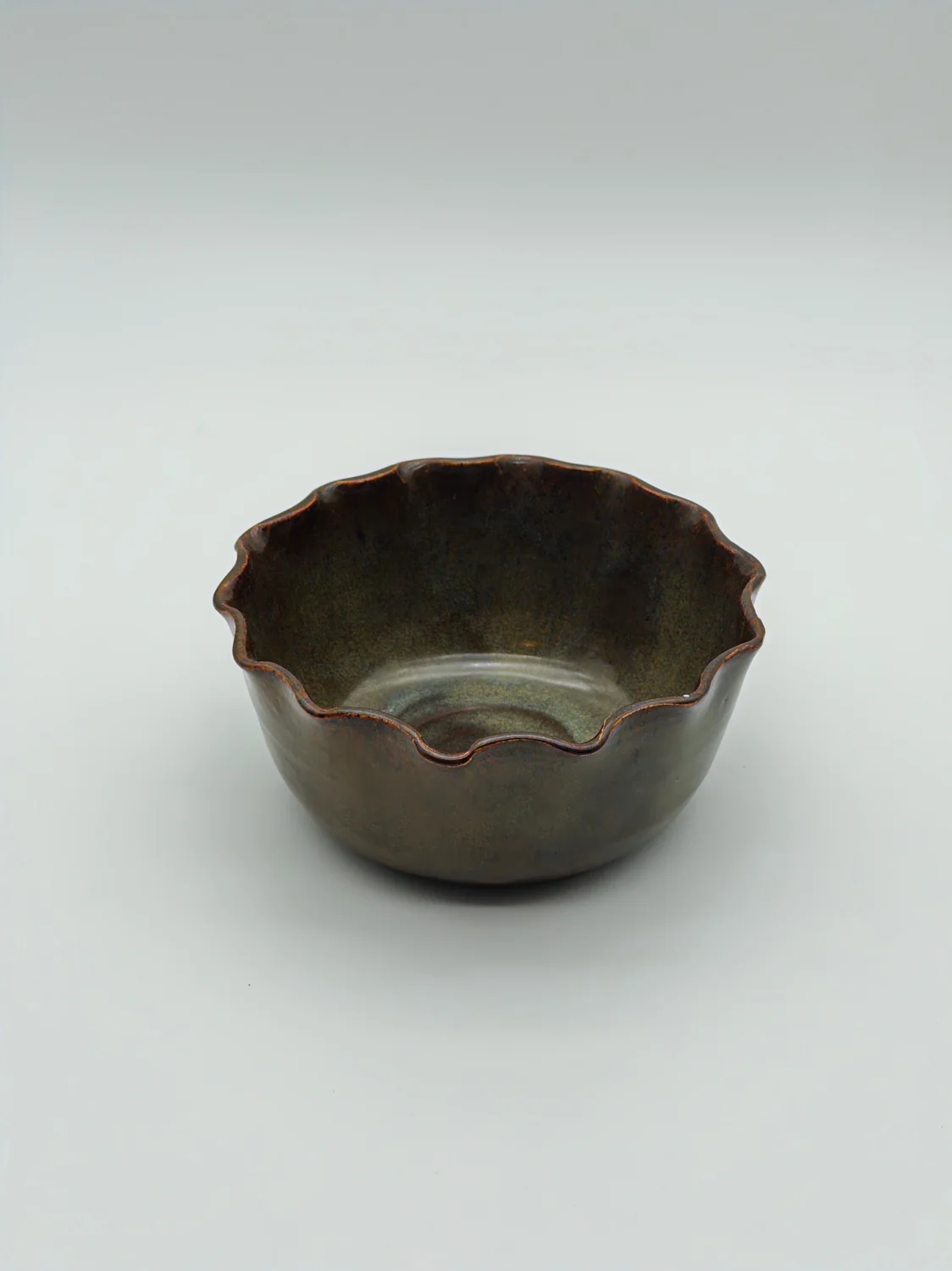 Small olive-brown bowl with a scalloped rim